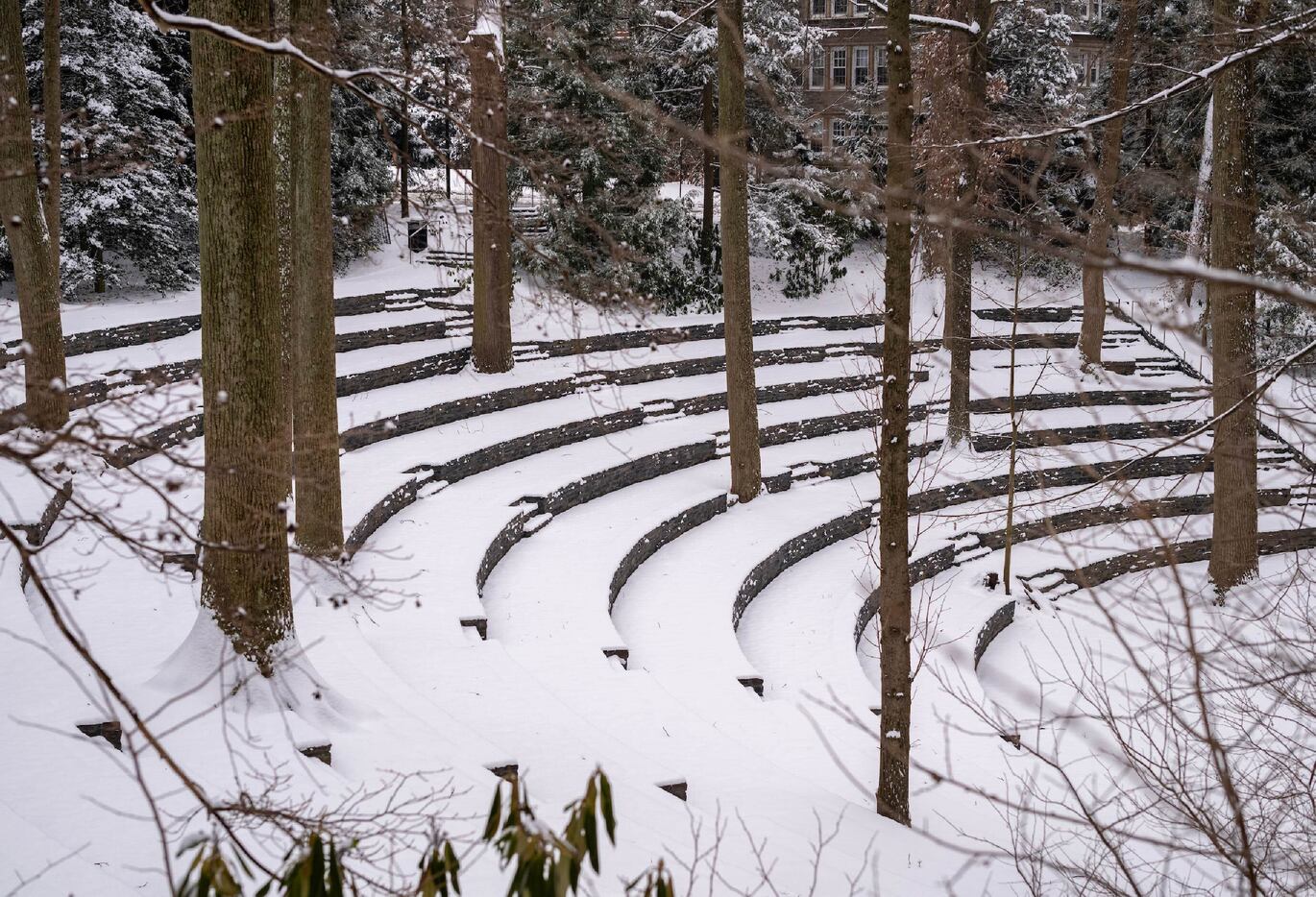 an image of an outdoor ampitheater with the circular seating areas covered by snow