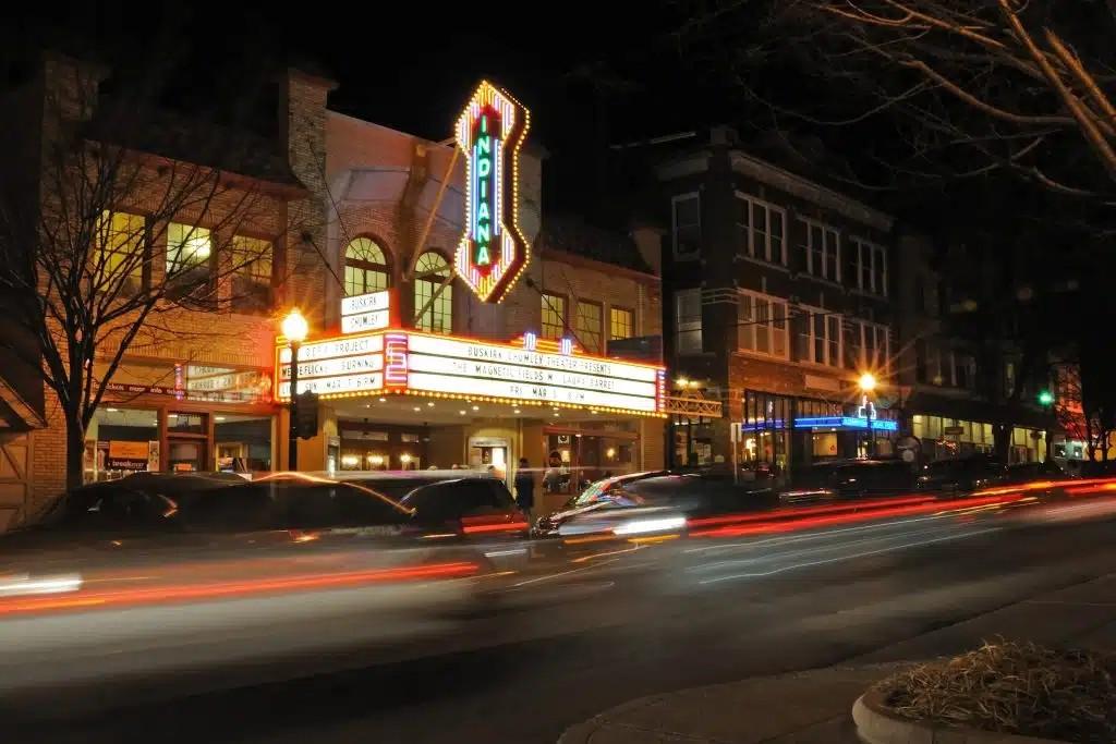 a night time image showing the marquee of the Buskirk-Chumley Theatre that is vertical and illuminated and reads "Indiana"
